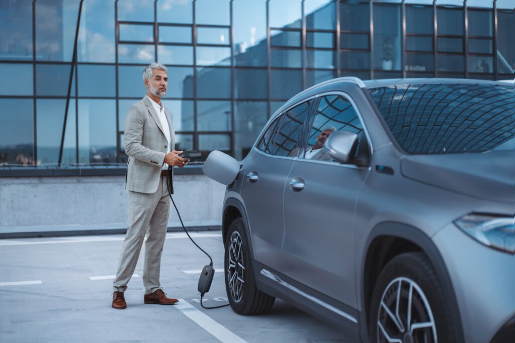 a businessman charging his electric car